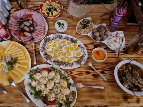 Una mesa de madera con platos de comida encima. en Salis Resort, en Wieliczka