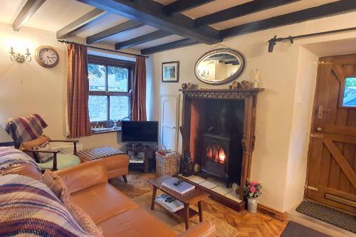 a living room with a couch and a fireplace at Stanton Cottage, Youlgrave Nr Bakewell in Bakewell