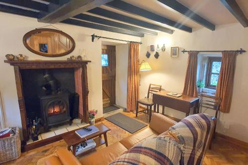 a living room with a couch and a fireplace at Stanton Cottage, Youlgrave Nr Bakewell in Bakewell