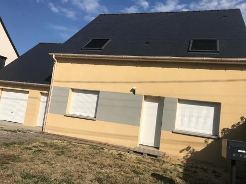 ein Haus mit drei Fenstern und einem schwarzen Dach in der Unterkunft Cosy studio, lit double in Le Mans