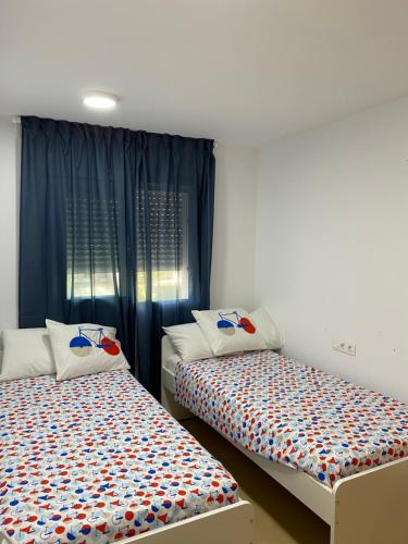 two beds sitting next to each other in a room at Appartement N618 avec solarium sur golf resort in Alhama de Murcia