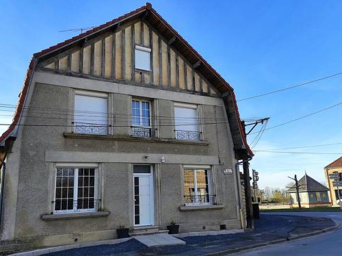 ein altes Haus mit zwei Fenstern und einem Balkon in der Unterkunft La Demeure d'Ana - Hébergement insolite in Voncq