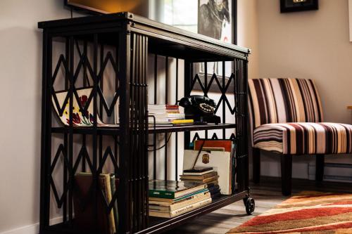 a black book shelf with books and a chair at The New Brunswick Bed and Breakfast in Saint Andrews