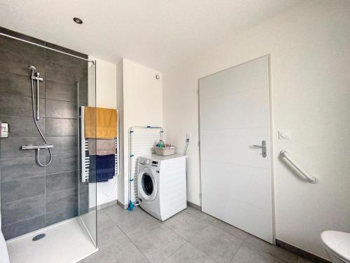 une salle de bain avec douche et machine à laver dans l'établissement Appartement 3 au calme dans le Sauternais, à Budos