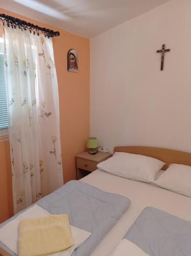 a bedroom with a bed and a cross on the wall at Casa Del Pellegrino M&A - Ostojići in Međugorje