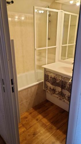une salle de bain avec un lavabo et une baignoire dans l'établissement Appartement cosy à Valmeinier avec vue montagne et piscine, à Valmeinier