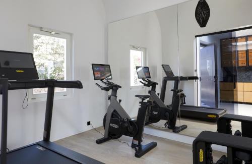 a gym with treadmills and exercise bikes in a room at The Saint Hotel in Oia
