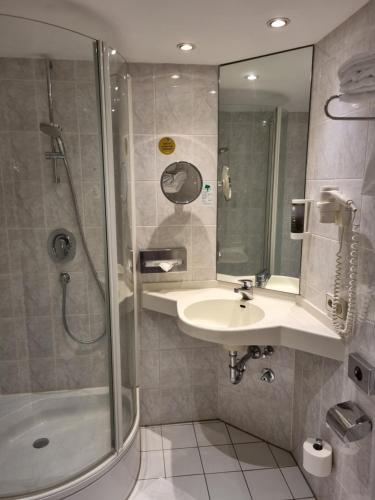 ein Bad mit einem Waschbecken und einer Dusche in der Unterkunft myMINGA4 - Hotel & serviced Apartments in München