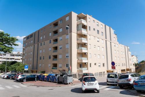 a parking lot with cars parked in front of a building at Apartment SUNČICA in Split