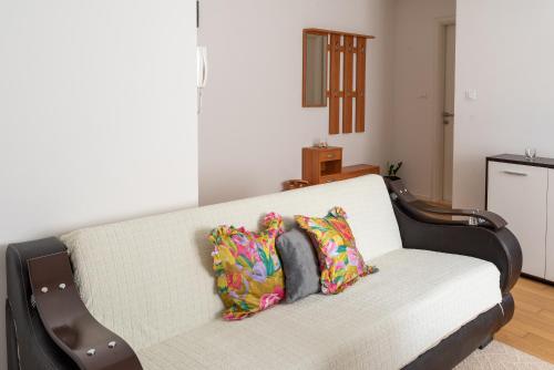 a couch with two pillows on it in a living room at Apartment SUNČICA in Split