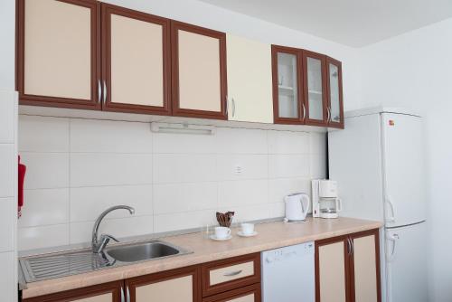 a kitchen with wooden cabinets and a sink at Apartment SUNČICA in Split