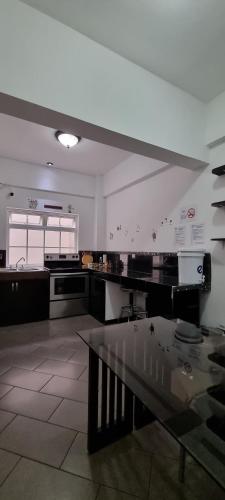 cocina grande con mesa de cristal en una habitación en Cayalito Apart Hotel en Guatemala