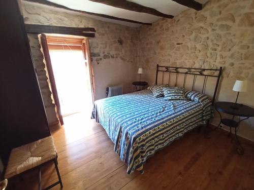 - une chambre avec un lit dans une pièce dotée d'une fenêtre dans l'établissement Casa Alta, à Valderrobres