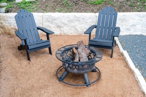 two blue chairs and a fire pit in a yard at THE VAQUERO MOTEL in Bandera