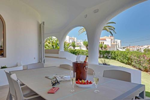 a table with wine glasses and a bowl of fruit on a patio at Villux - Vila Enar-6 quartos, ideal para familias in Albufeira
