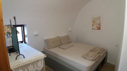a small white room with a bed and a window at Kytherian Traditional Home in Friligkianika