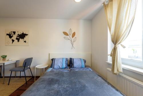 ein Schlafzimmer mit einem Bett, einem Schreibtisch und einem Fenster in der Unterkunft Vienna Lights Apartments - Hernals in Wien