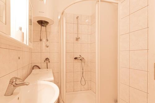 ein Bad mit einer Dusche, einem Waschbecken und einem WC in der Unterkunft Apartment Nocturno in Rogoznica