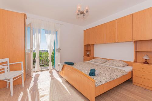 een slaapkamer met een groot bed en een raam bij Apartment Nocturno in Rogoznica