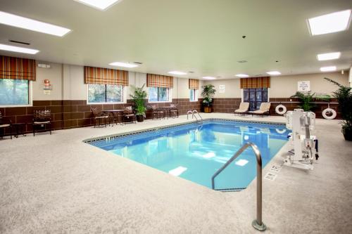 a pool in a hotel room with chairs and tables at Holiday Inn Express Hotel & Suites - Atlanta/Emory University Area by IHG in Decatur