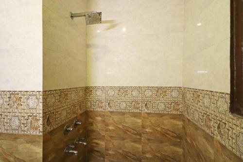 baño con ducha con azulejos en la pared en Silver Shine New Delhi - COMFORT STAY, en Nueva Delhi