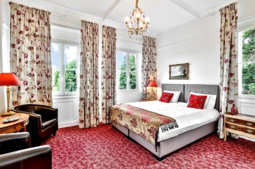 - une chambre avec un lit, une chaise et des fenêtres dans l'établissement Château de Villars, à Villars