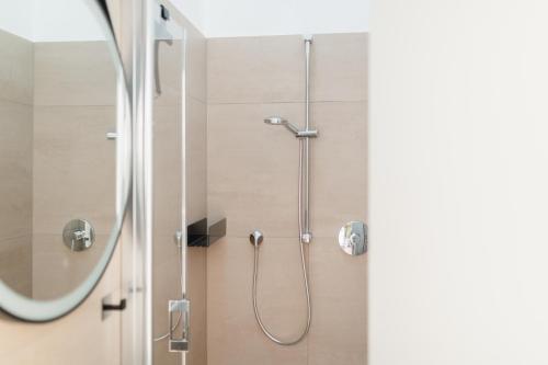 a shower with a glass door and a shower head at Quartier M12 in Norderney