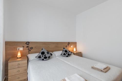 - une chambre avec un grand lit blanc et 2 oreillers dans l'établissement Albamar Apartamento 6 personas con parking cerca de la playa, à Calp