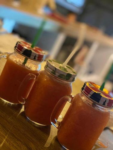 three mason jars filled with juice on a table at Nilaveli Hybrid Holiday Hotel in Nilaveli
