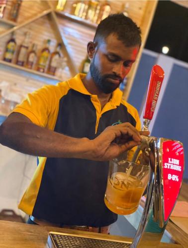 a man is making a drink in a blender at Nilaveli Hybrid Holiday Hotel in Nilaveli