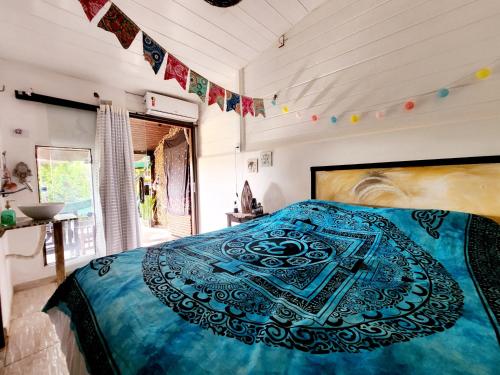 a bedroom with a large bed with a blue blanket at Pousada Magia in Fernando de Noronha