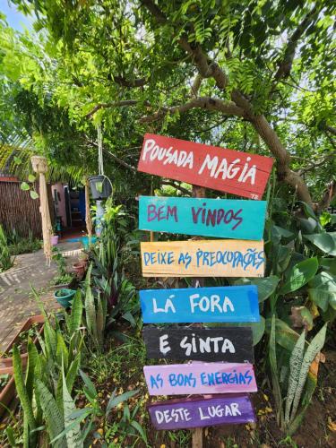 a stack of signs with different languages at Pousada Magia in Fernando de Noronha