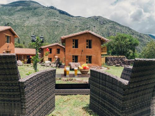 una cerca frente a una casa con montañas en el fondo en Unuwasi Hotel & Villa en Calca