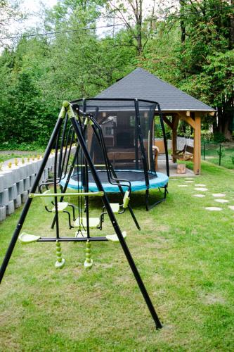 a swing set in a yard with a gazebo at Chata Nezábudka in Oščadnica