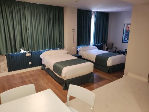 pokój hotelowy z 2 łóżkami, stołem i krzesłami w obiekcie Modo Hotel Apartamento w mieście Parla
