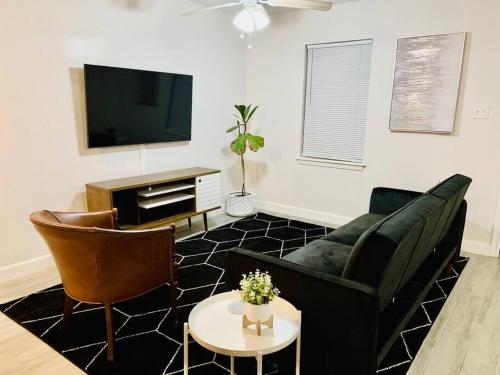 a living room with a couch and a tv at Mayfield @ Oyster Creek - Tranquil Creek & Nature! in Sugar Land