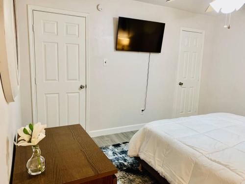 a bedroom with a bed and a table and a tv at Mayfield @ Oyster Creek - Tranquil Creek & Nature! in Sugar Land