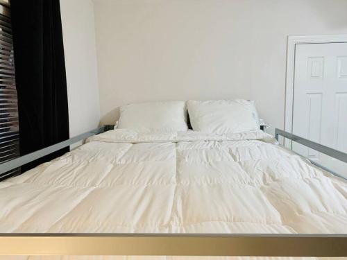 a bed with white sheets and pillows in a room at Mayfield @ Oyster Creek - Tranquil Creek & Nature! in Sugar Land