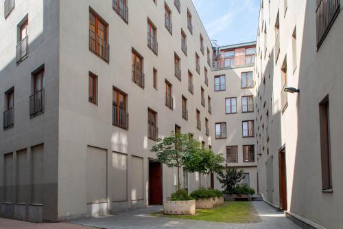 an alley between two tall buildings with a tree at Spacious brand new modern apartment in Old Town in Rīga