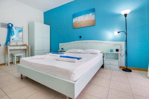 a bedroom with a white bed and a blue wall at Malandris Studios in Skala Marion