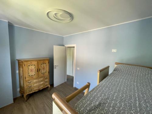 a bedroom with a bed and a wooden dresser at Appartamento Luigi in Ventimiglia