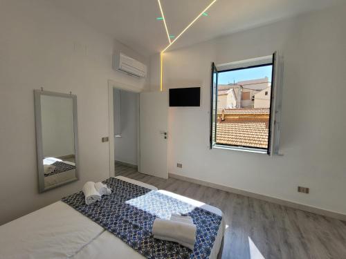 Una habitación blanca con una cama y un espejo. en Sara luxury apartment 3, en Sorrento