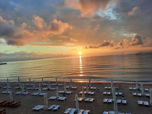 a group of chairs on a beach at sunset at Aqua Villa by the Sea in Eforie Sud