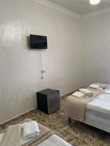 a room with two beds and a tv on the wall at Hotel Georgia in Gonio