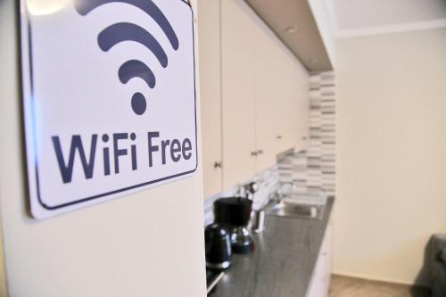 a wifi sign on a wall in a kitchen at John's apartment's near Athens Airport!! in Spáta
