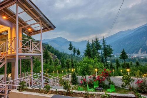 a building with a view of the mountains at Baan by Snow City Farm in Vashisht