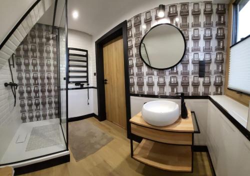 La salle de bains est pourvue d'un lavabo et d'un miroir sur une table. dans l'établissement Willa Pod Reglami, à Zakopane