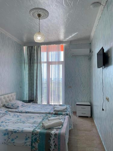 a bedroom with two beds and a tv and a window at Hotel Georgia in Gonio