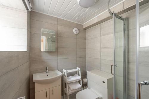 a bathroom with a sink and a toilet and a shower at Milo's place is a home from home in Egremont