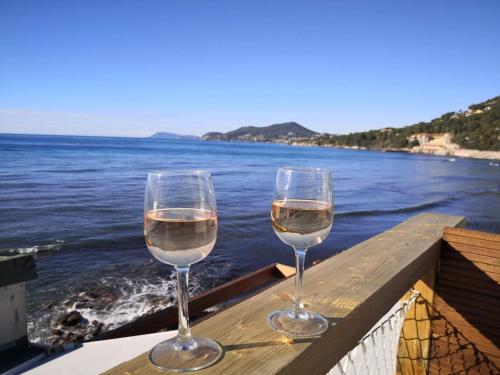 two glasses of wine sitting on a ledge overlooking the water at Stella Maris in Hyères